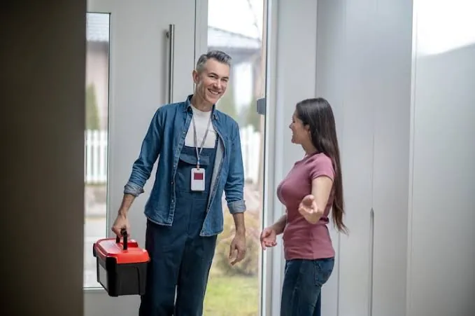 Técnico llegando a la casa de una clienta con su caja de herramientas